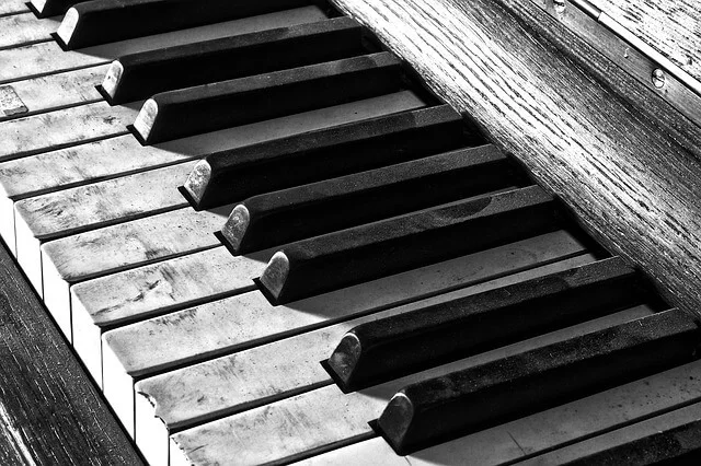Teclado antiguo en blanco y negro sobre madera veteada